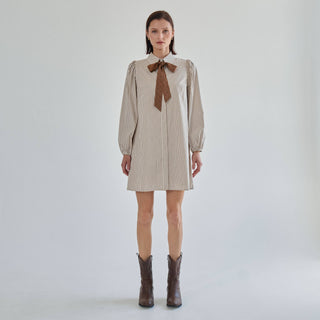 Model in the Marguerite cream and mocha striped bow tie shirt dress with brown western boots, front view